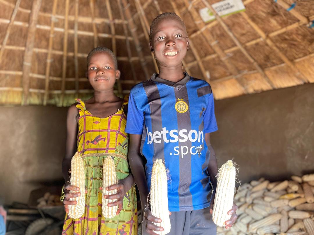 Happy children showing their harvested maize