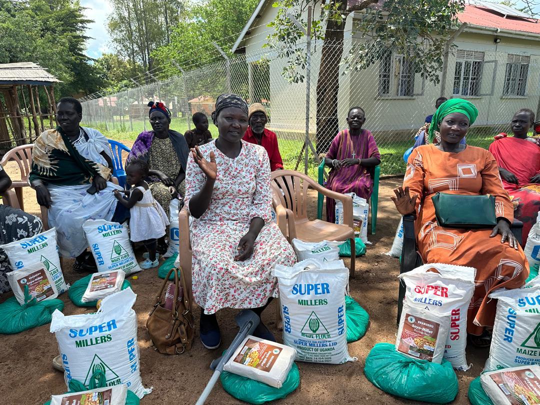 Community members happily waving after receiving the mercy bags